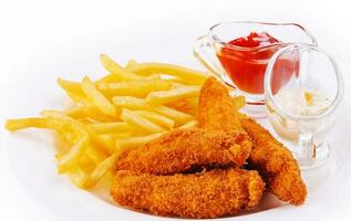 Chicken nuggets with french fries on plate photo