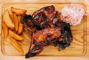 Pork ribs with baked potatoes and cabbage salad photo