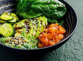 poke bowl with salmon, avocado and cucumber photo