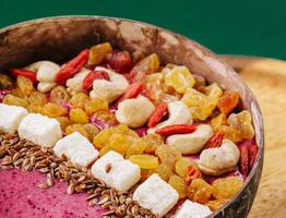 Healthy breakfast raisins and cashew nuts smoothie in coconut bowl photo