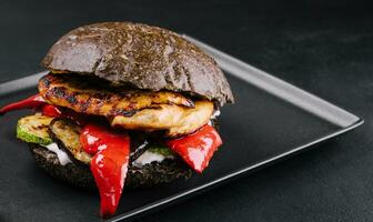 Fresh tasty chicken burger on a black tray photo