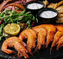 Traditional greek grilled seafood on restaurant wooden plate photo