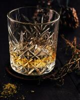 Glass of whiskey on wooden table photo