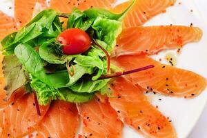 Slices of raw salmon fillet on white plate photo