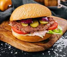 Close-up of home made burger on wooden tray photo
