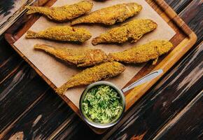 Fried smelt on a wooden chopping board photo