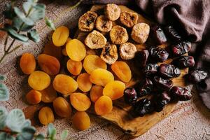 Different dried fruits on wooden background photo