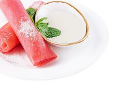 Rolled raspberry pancakes on white plate photo