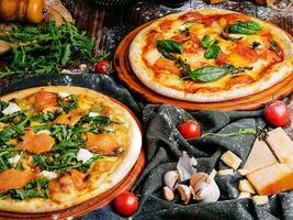 Two Different Pizzas on wooden table photo