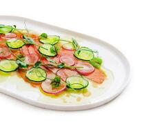 Buffet serving of pickled salmon slices with radish, cucumber photo