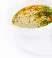 Chicken soup or broth with noodles, herbs and hot green pepper photo