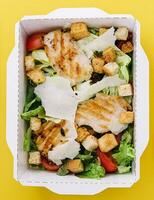 Caesar salad packed on craft box for take away photo