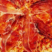 Pizza with prosciutto, cheese, tomato sauce photo