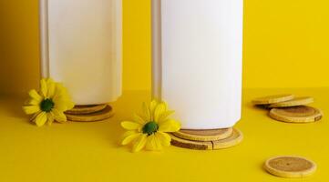 cosmetic products with chamomile flowers on yellow background photo