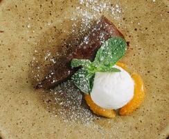 Chocolate brownie with ice cream and vanilla powder on plate photo