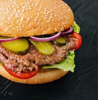 Tasty cheeseburger isolated on black stone photo