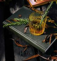 Whiskey in a glass with ice on book photo