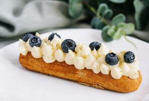 Tasty French eclairs with cream and fresh berries photo