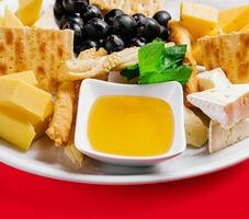 Different types of cheese on a white plate photo