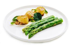 Freshly sauteed scallops with green asparagus photo