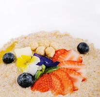 Oatmeal with strawberries, blueberries and hazelnuts photo