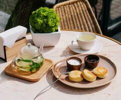 Traditional breakfast with tea and cottage cheese pancakes photo