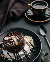 Plate with fresh brownies and ice-cream on black plate photo