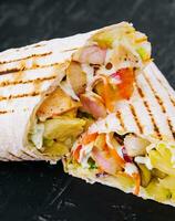 Delicious chicken shawarma on black stone photo