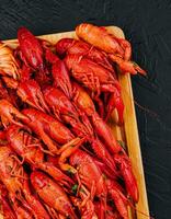 Fragrant boiled crayfish on a wooden board photo