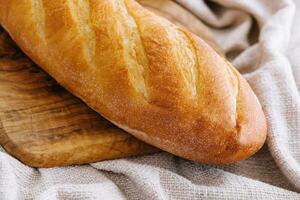 A loaf of bread on a wooden board photo