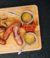 Delicious fresh grilled sausages on wooden table photo
