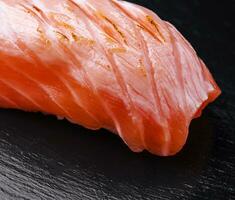 Salmon sushi on black wood background photo