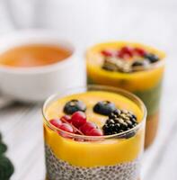 Healthy vegan chia pudding with mango sauce and fresh berries photo