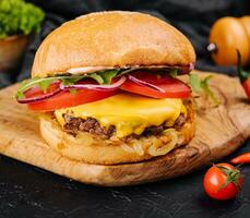 sabroso A la parrilla hogar hecho hamburguesa con carne de res, tomate, queso, cebolla y lechuga. foto