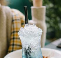 young woman drinking blue lagoon cocktail photo