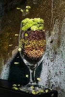glass with foam together with wheat, seeds and hops photo