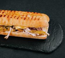 Big sandwich with chicken on stone board photo