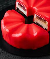 Contemporary Chocolate Cherry Mousse Cake covered with cherry icing photo