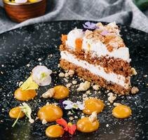 Carrot cake with walnuts on black plate photo