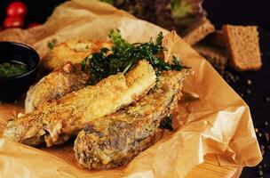 fried fish with garlic sauce on a cutting board photo