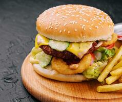 Juicy burger with onion rings and french fries photo