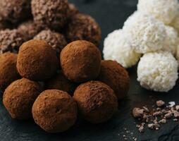 three types of chocolate balls on stone board photo