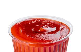 ketchup in a plastic bowl isolated on white photo