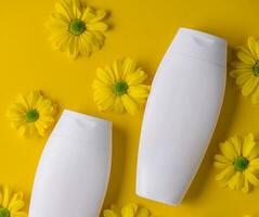 Bottle of Mockup cosmetic products with chamomile flowers photo
