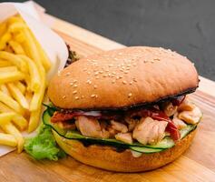 hamburguesa con papas fritas en de madera rústico tablero foto