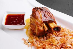 Bavarian pork knuckle with sauerkraut on plate photo