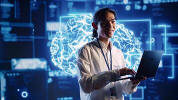 Asian admin in data center using artificial intelligence computing simulating human brain thought processes in computerized model. Employee holding laptop, working with AI machine learning algorithms photo