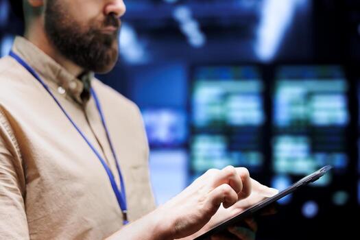 Close up shot of system administrator using tablet to check high tech establishment security features protecting against unauthorized access, data breach, ddos attacks and other cybersecurity dangers photo