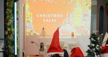 Revealing dolly in shot of digital screen billboard with Christmas sales advertisement written on it, promoting festive promotional offers in xmas adorn fashion boutique during winter holiday season photo