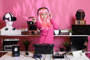 asiático músico ejecutando electrónico música utilizando DJ mezclador consola disfrutando a jugar canción con aficionados, teniendo divertido en club a noche. artista haciendo actuación con profesional audio equipo foto